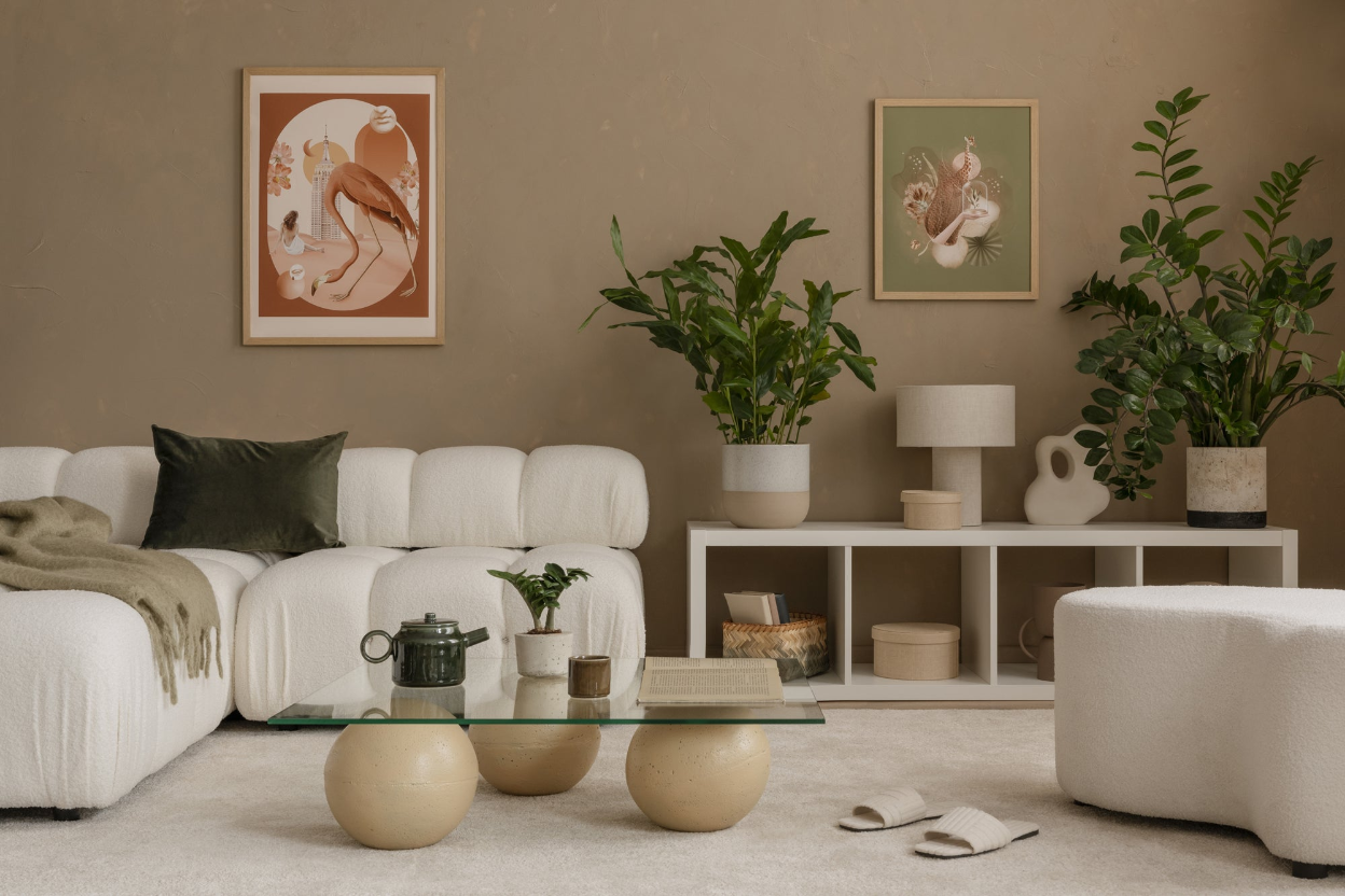 Modern living room with a beige sofa, glass coffee table, and decorative plants.